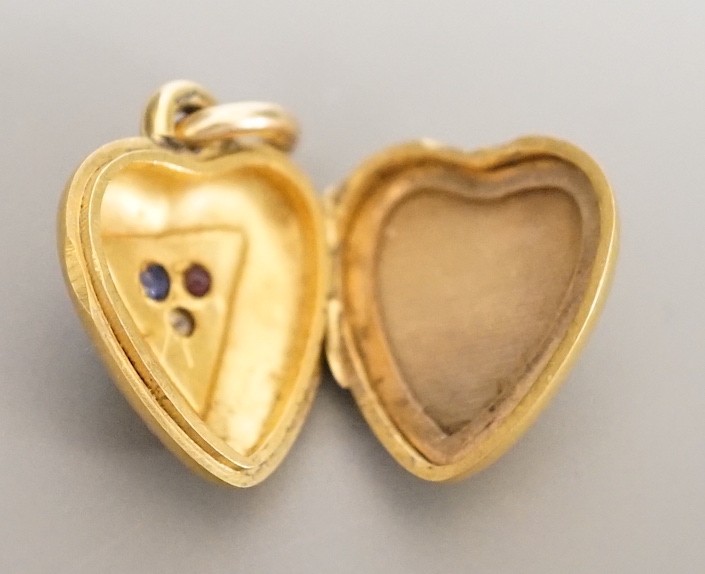 An Edwardian 15ct, sapphire, diamond and ruby set heart shaped locket, 17mm, gross weight 5.7 grams.